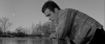 Movie still from “Sons and Lovers” (1960), directed by Jack Cardiff – A man leaning on a fence looking at a body of water; Close Up shot, Low angle