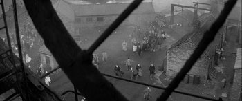 Movie still from “Sons and Lovers” (1960), directed by Jack Cardiff – A black and white photo of people walking on a street; Extreme Wide shot, High angle