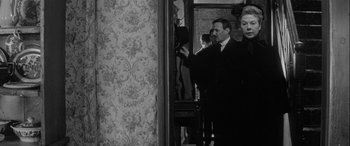 Movie still from “Sons and Lovers” (1960), directed by Jack Cardiff – A man and a woman standing next to each other in a room; Medium shot, Over the shoulder angle