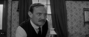 Movie still from “Sons and Lovers” (1960), directed by Jack Cardiff – An older man wearing a vest and a tie; Close Up shot, Over the shoulder angle