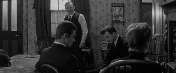 Movie still from “Sons and Lovers” (1960), directed by Jack Cardiff – A group of men sitting around a table; Medium shot, Over the shoulder angle