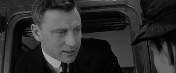 Movie still from “Sons and Lovers” (1960), directed by Jack Cardiff – Black and white photograph of a man wearing a suit and tie; Close Up shot, Over the shoulder angle