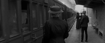 Movie still from “Sons and Lovers” (1960), directed by Jack Cardiff – An older woman is walking on a train platform; Medium shot, Over the shoulder angle