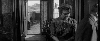 Movie still from “Sons and Lovers” (1960), directed by Jack Cardiff – A woman sitting in a chair in a room; Medium shot, Low angle