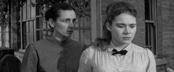 Movie still from “Sons and Lovers” (1960), directed by Jack Cardiff – A woman standing next to another woman in a black and white photo; Close Up shot, Over the shoulder angle