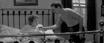 Movie still from “Sons and Lovers” (1960), directed by Jack Cardiff – An old photo of a man and a woman in a hospital bed; Medium shot, High angle