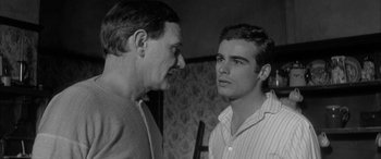 Movie still from “Sons and Lovers” (1960), directed by Jack Cardiff – Two men talking to each other in front of a wall; Close Up shot, Over the shoulder angle