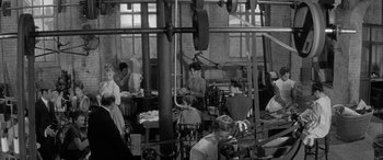 Movie still from “Sons and Lovers” (1960), directed by Jack Cardiff – A group of people working in an industrial setting; Wide shot, High angle