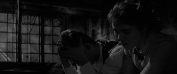 Movie still from “Sons and Lovers” (1960), directed by Jack Cardiff – Two men are standing in a dark room; Close Up shot, Over the shoulder angle