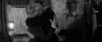 Movie still from “Sons and Lovers” (1960), directed by Jack Cardiff – A man and a woman hugging in a living room; Medium shot, Over the shoulder angle