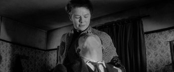 Movie still from “Sons and Lovers” (1960), directed by Jack Cardiff – An older woman is holding a dog in her arms; Close Up shot, Low angle