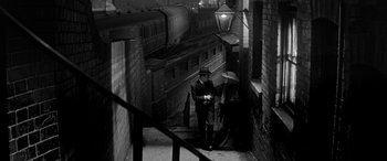 Movie still from “Sons and Lovers” (1960), directed by Jack Cardiff – A man and a woman walking down the stairs of an alley; Wide shot, High angle