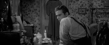 Movie still from “Sons and Lovers” (1960), directed by Jack Cardiff – A man sitting in front of a candle on a table; Medium shot, Over the shoulder angle