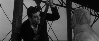 Movie still from “Sons and Lovers” (1960), directed by Jack Cardiff – A black and white photo of a man holding onto a pole; Medium shot, Low angle