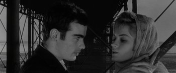 Movie still from “Sons and Lovers” (1960), directed by Jack Cardiff – A man and a woman face to face in front of a bridge; Close Up shot, Low angle