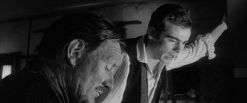 Movie still from “Sons and Lovers” (1960), directed by Jack Cardiff – A man and a man standing next to each other in a room; Close Up shot, Over the shoulder angle