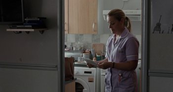 Movie still from “Sorry We Missed You” (2019), directed by Ken Loach – A woman standing in a kitchen holding a tablet; Medium shot, Low angle