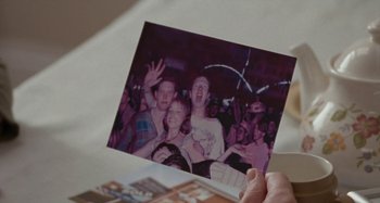 Movie still from “Sorry We Missed You” (2019), directed by Ken Loach – A person holding up a picture of a group of people at an event; Extreme Close Up shot, High angle