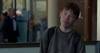 Movie still from “Sorry We Missed You” (2019), directed by Ken Loach – A man with a backpack standing in front of a building; Close Up shot, Over the shoulder angle