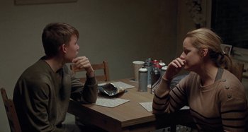Movie still from “Sorry We Missed You” (2019), directed by Ken Loach – Two people sitting at a dinner table eating food; Medium shot, Over the shoulder angle