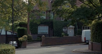 Movie still from “Sorry We Missed You” (2019), directed by Ken Loach – A house with a brick wall and a brick fence on the side of the house; Extreme Wide shot, Low angle