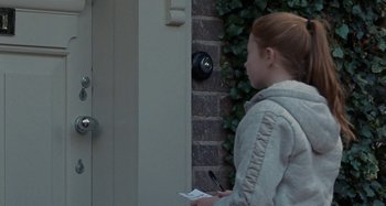 Movie still from “Sorry We Missed You” (2019), directed by Ken Loach – A young girl standing in front of a door; Medium shot, Over the shoulder angle