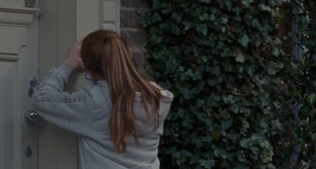 Movie still from “Sorry We Missed You” (2019), directed by Ken Loach – A girl with long red hair leaning against a wall; Medium shot, High angle