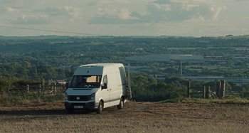 Movie still from “Sorry We Missed You” (2019), directed by Ken Loach – A white van parked on top of a brown field; Extreme Wide shot, High angle