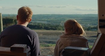 Movie still from “Sorry We Missed You” (2019), directed by Ken Loach – Two people looking out over a valley from a hill; Medium shot, Over the shoulder angle