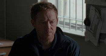 Movie still from “Sorry We Missed You” (2019), directed by Ken Loach – A person wearing a jacket near a window; Close Up shot, Over the shoulder angle