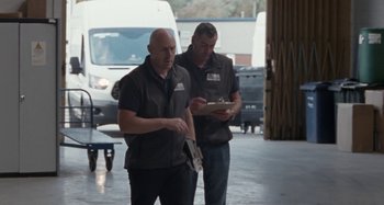 Movie still from “Sorry We Missed You” (2019), directed by Ken Loach – Two men are standing in front of a van; Medium shot, Low angle