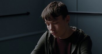 Movie still from “Sorry We Missed You” (2019), directed by Ken Loach – A young man sitting in front of a table; Close Up shot, Low angle