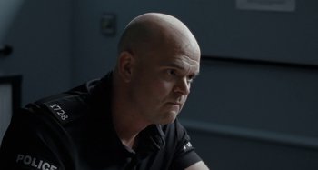 Movie still from “Sorry We Missed You” (2019), directed by Ken Loach – A man with a bald head looking at the camera; Close Up shot, Over the shoulder angle