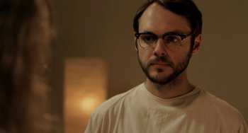 Movie still from “Sound of My Voice” (2011), directed by Zal Batmanglij – A person wearing glasses and a white shirt; Close Up shot, Over the shoulder angle