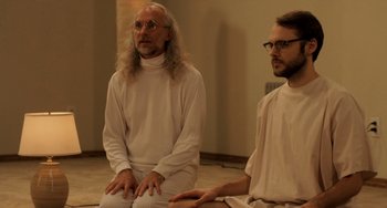 Movie still from “Sound of My Voice” (2011), directed by Zal Batmanglij – Two men in white clothes sitting on the ground; Medium shot, Over the shoulder angle