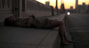 Movie still from “Sound of My Voice” (2011), directed by Zal Batmanglij – A person laying on the side of a road; Wide shot, Low angle