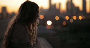 Movie still from “Sound of My Voice” (2011), directed by Zal Batmanglij – A woman with long blonde hair is looking at the sunset; Close Up shot, High angle