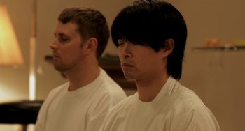 Movie still from “Sound of My Voice” (2011), directed by Zal Batmanglij – Two men in white shirts are sitting in a room; Close Up shot, Low angle