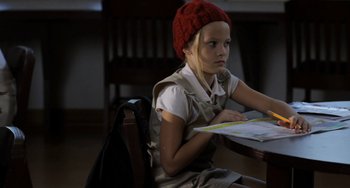 Movie still from “Sound of My Voice” (2011), directed by Zal Batmanglij – A young girl sitting at a table with a book; Medium shot, High angle