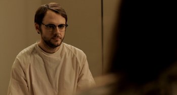 Movie still from “Sound of My Voice” (2011), directed by Zal Batmanglij – A man with glasses sitting in front of a mirror; Close Up shot, Over the shoulder angle