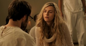 Movie still from “Sound of My Voice” (2011), directed by Zal Batmanglij – A woman with long blonde hair is talking to a man; Close Up shot, Over the shoulder angle