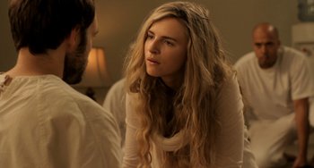 Movie still from “Sound of My Voice” (2011), directed by Zal Batmanglij – A woman with long blonde hair sitting next to a man; Close Up shot, Over the shoulder angle