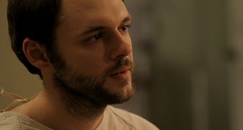 Movie still from “Sound of My Voice” (2011), directed by Zal Batmanglij – A person with a beard; Close Up shot, Over the shoulder angle