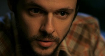 Movie still from “Sound of My Voice” (2011), directed by Zal Batmanglij – A person with a beard; Extreme Close Up shot, High angle