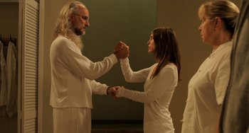 Movie still from “Sound of My Voice” (2011), directed by Zal Batmanglij – A man and a woman holding hands in a room; Medium shot, Low angle