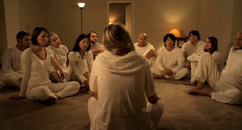 Movie still from “Sound of My Voice” (2011), directed by Zal Batmanglij – A group of people sitting in a circle with a woman; Wide shot, High angle