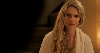 Movie still from “Sound of My Voice” (2011), directed by Zal Batmanglij – A woman with long blonde hair sitting in front of a staircase; Close Up shot, Over the shoulder angle
