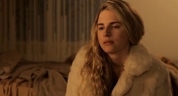 Movie still from “Sound of My Voice” (2011), directed by Zal Batmanglij – A beautiful young lady sitting on top of a couch; Close Up shot, Over the shoulder angle