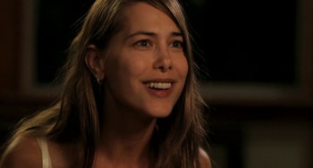 Movie still from “Sound of My Voice” (2011), directed by Zal Batmanglij – A beautiful young lady smiling for the camera; Close Up shot, Over the shoulder angle
