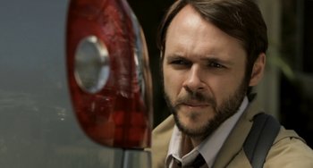 Movie still from “Sound of My Voice” (2011), directed by Zal Batmanglij – A person wearing a suit and tie; Close Up shot, Over the shoulder angle